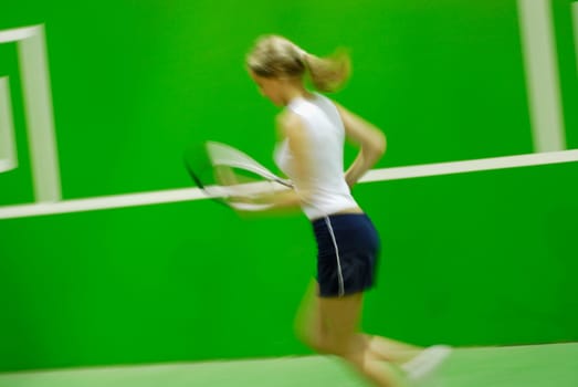 Side profile of a young woman playing tennis
