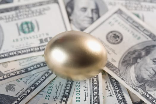 Close_up of a golden egg on US paper currency