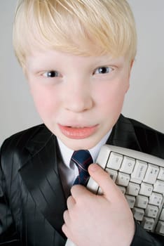 Close_up of a boy holding a computer keyboard
