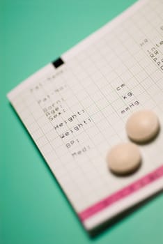 Close_up of two pills on a medical record