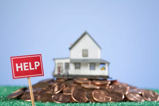 Help sign board in front of a model home on a pile of coins
