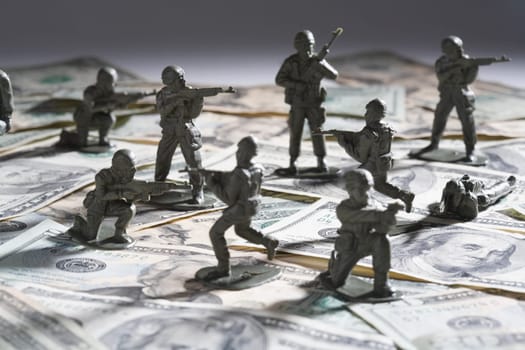 Close_up of plastic toys fighting on paper currency