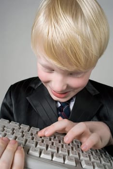 Close_up of a boy holding a computer keyboard