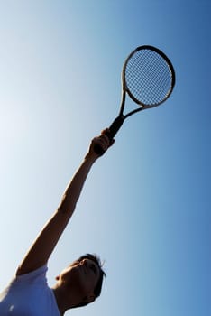 Low angle view of a mid adult woman holding a tennis racket