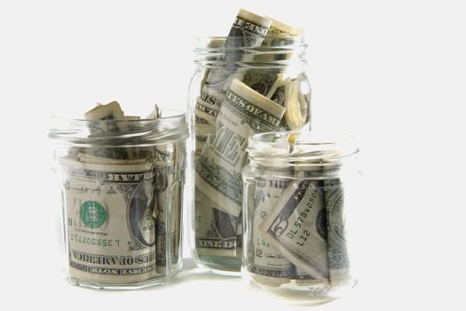 Dollar bills squashed into three jars