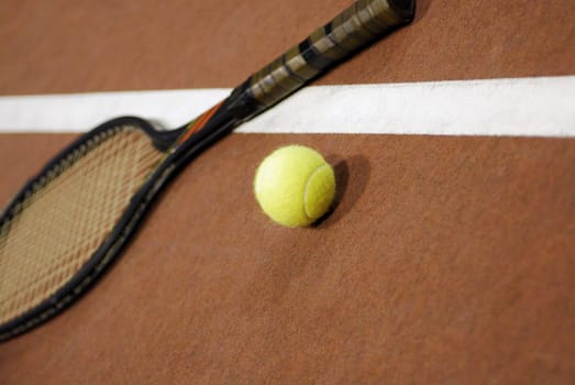 Close-up of a tennis ball with a tennis racket on a tennis court