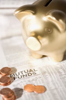 Piggy bank and coins on a financial newspaper