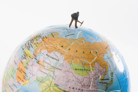 Figurine of a manual worker working on a globe
