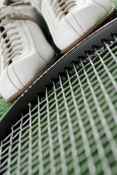 Close-up of a pair of sports shoes and a tennis racket