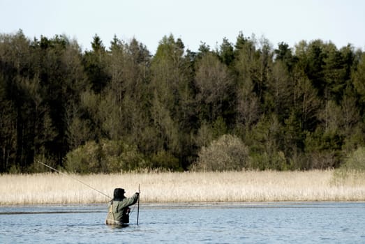 Rear view of a man fishing in the river