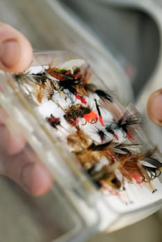 Close-up of a personŽs hand holding a box of flies and lures