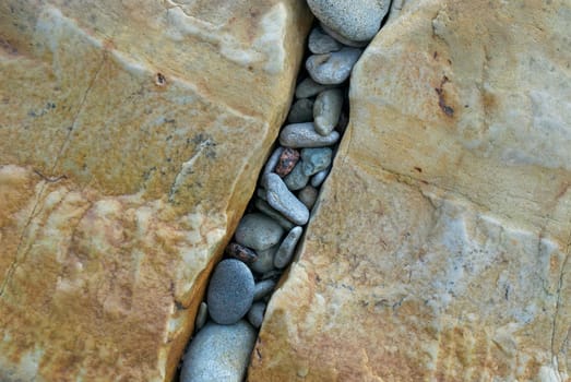 High angle view of pebbles in a gap of rocks