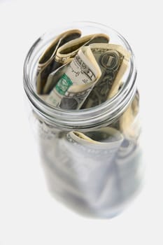 Dollar bills squashed into a jar