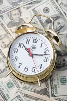 Close_up of an alarm clock on paper currency