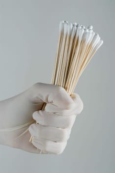 Close_up of a personŽs hand holding cotton swabs