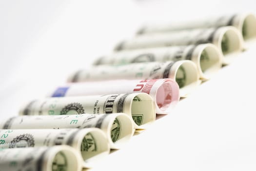 Rolls of US paper currency with European union euro note