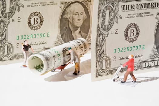 Figurines of manual workers with US dollar bills