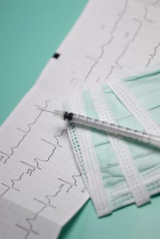 Close_up of a syringe on an electrocardiogram report