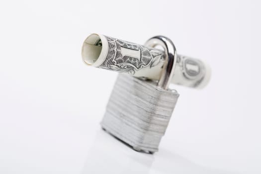 Close_up of a rolled bank note with a padlock