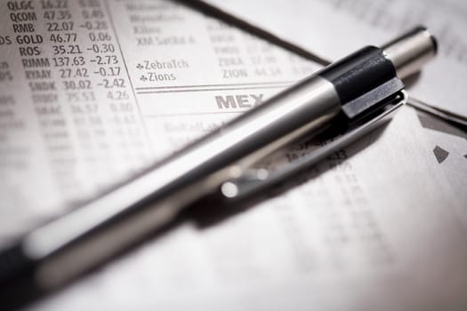 Close_up of a pen on financial newspapers