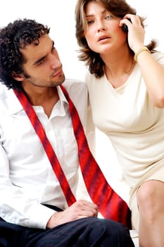 Portrait of a young woman talking on a mobile phone with a young man sitting beside her
