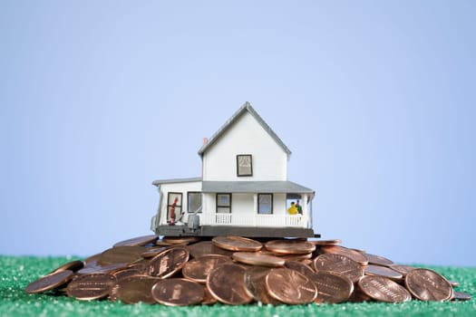 Close_up of a model home on a pile of coins
