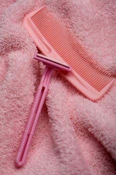 High angle view of a razor and a comb on a towel