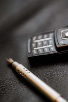 Close-up of a fountain pen near a mobile phone