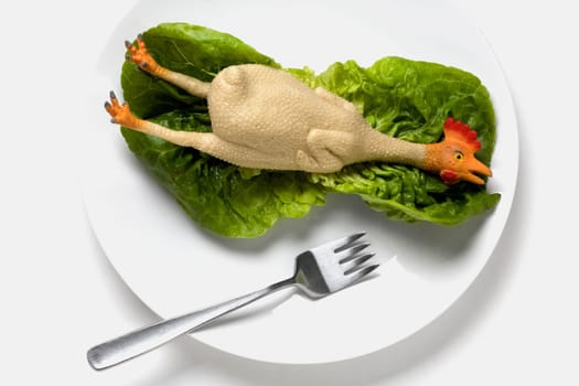 High angle view of figurine of a chicken on a lettuce leaf