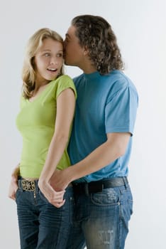 Young man whispering into a young womanŽs ear
