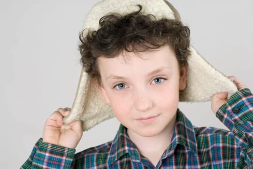 Close_up of a boy wearing a fur hat