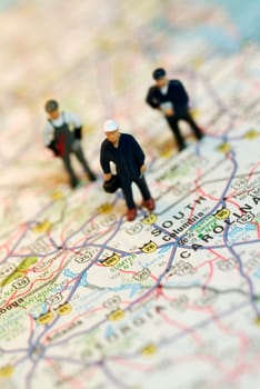 Close-up of the figurines of three construction workers on a map