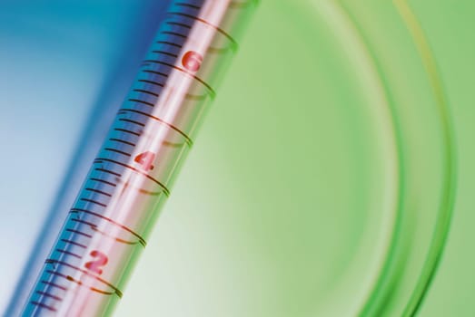 Close_up of a syringe with a petri dish
