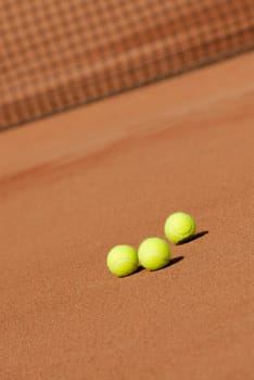 Three tennis balls on a tennis court