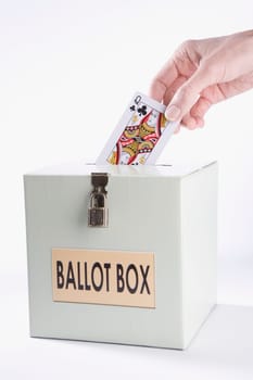 PersonŽs hand inserting a playing card into a ballot box