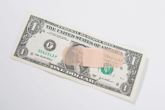 Adhesive bandage on a US dollar bill