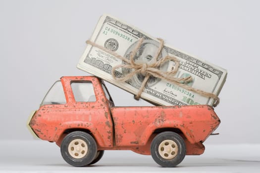Close_up of a toy truck loading a bundle of paper currency