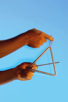 Close-up of a musicianŽs hands playing the triangle