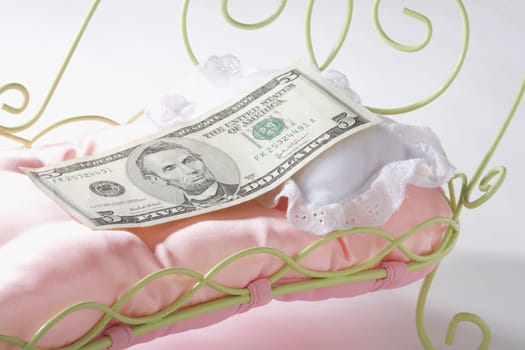 Five US dollar bill on a miniature bed