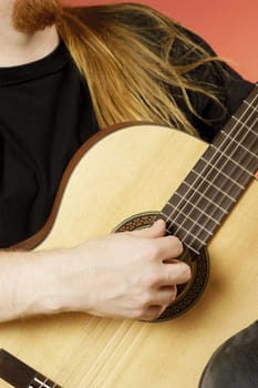 Mid section view of a musician playing an acoustic guitar