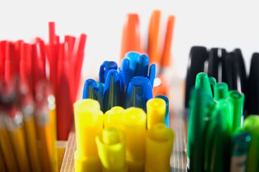 Close-up of colored pens in pen stands