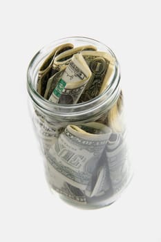 Dollar bills squashed into a jar