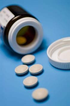 Close_up of pills with a bottle