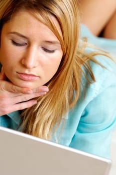 Businesswoman lying in front of a laptop