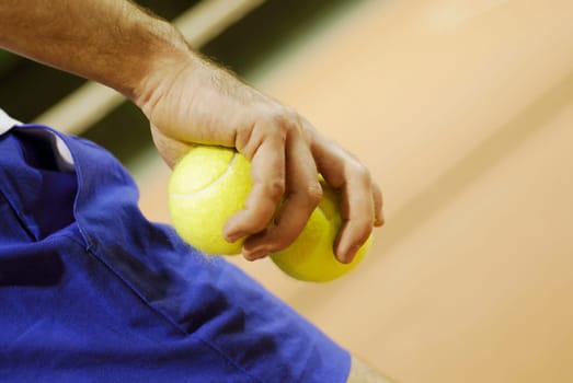 Mid section view of a man holding two tennis balls