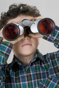 Close_up of a boy looking through a pair of binoculars