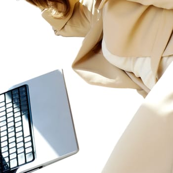 Mid section view of a businesswoman lying in front of a laptop