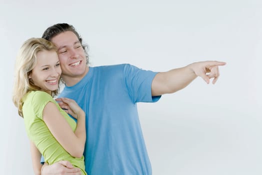 Young man pointing with a young woman standing beside him