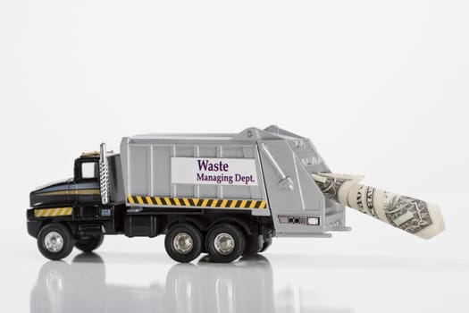 Close_up of toy garbage truck carrying US dollar bill