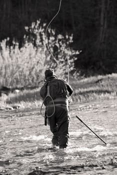 Rear view of a man fishing in the river